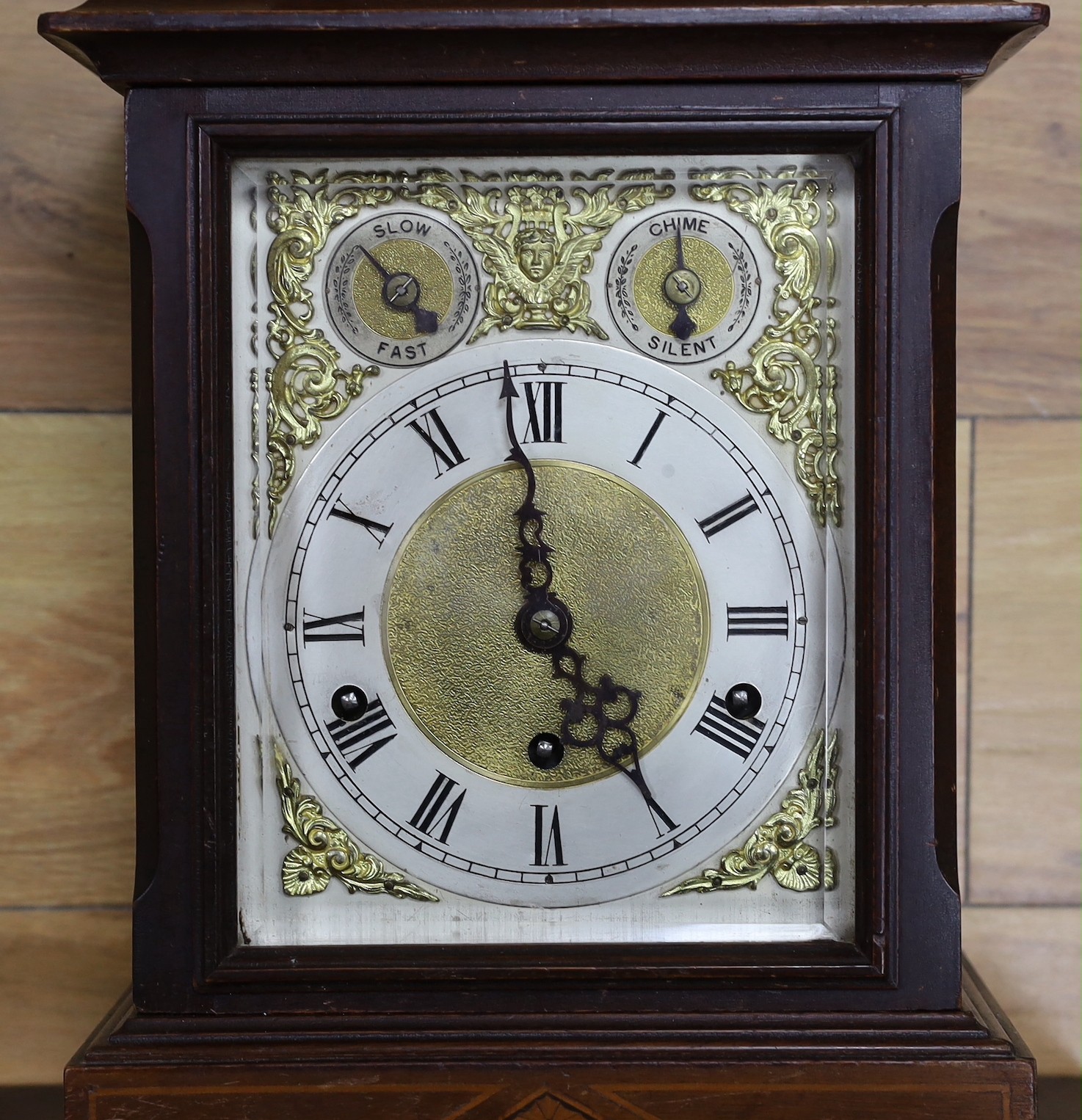 A Edwardian inlaid mahogany bracket clock, with traditional dial and chiming mechanism, clock 37cms high, bracket 33cms high